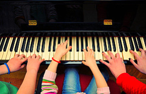 Three kids playing piano. Shallow DOF.