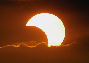 The moon casts a shadow at the sun blocking it partially in a partial solar eclipse